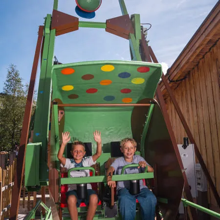 Kinder auf Fahrgeschäft im Familienland Erlebnispark