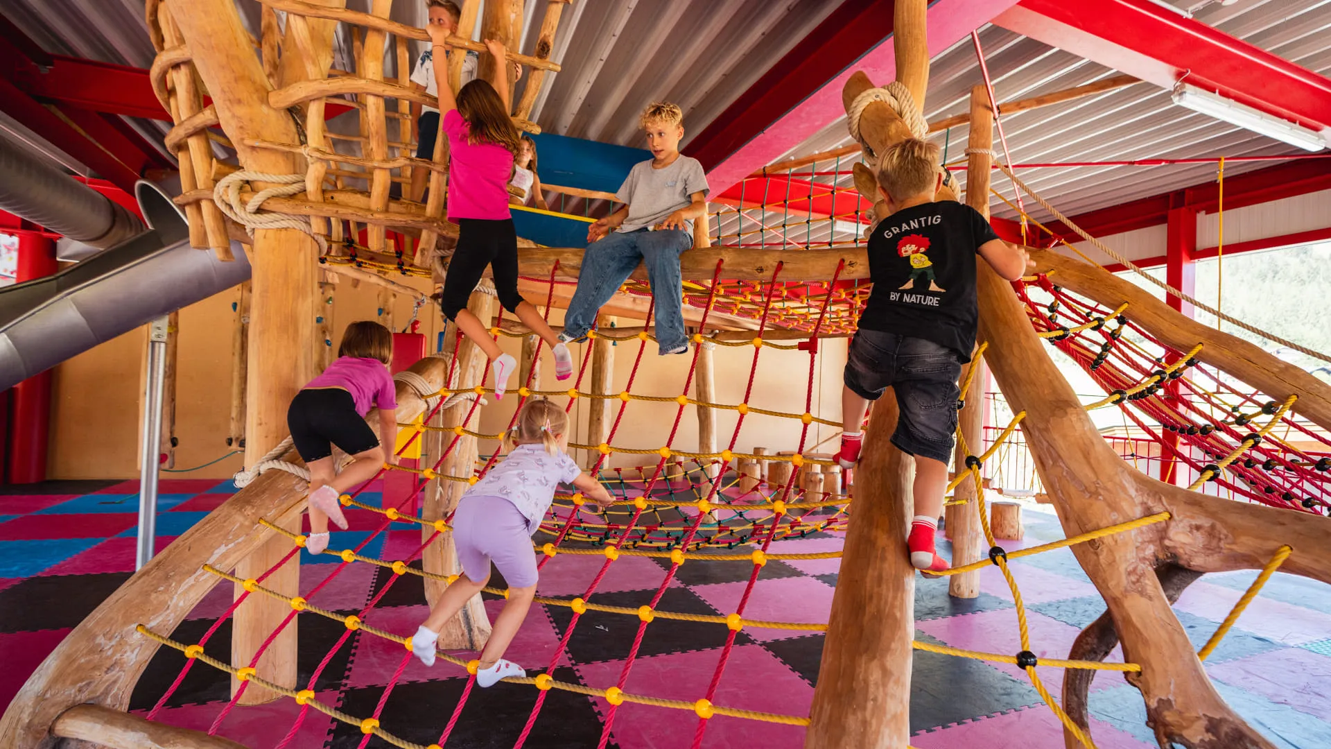 Kinder spielen auf einem Klettergerüst im Erlebnispark.