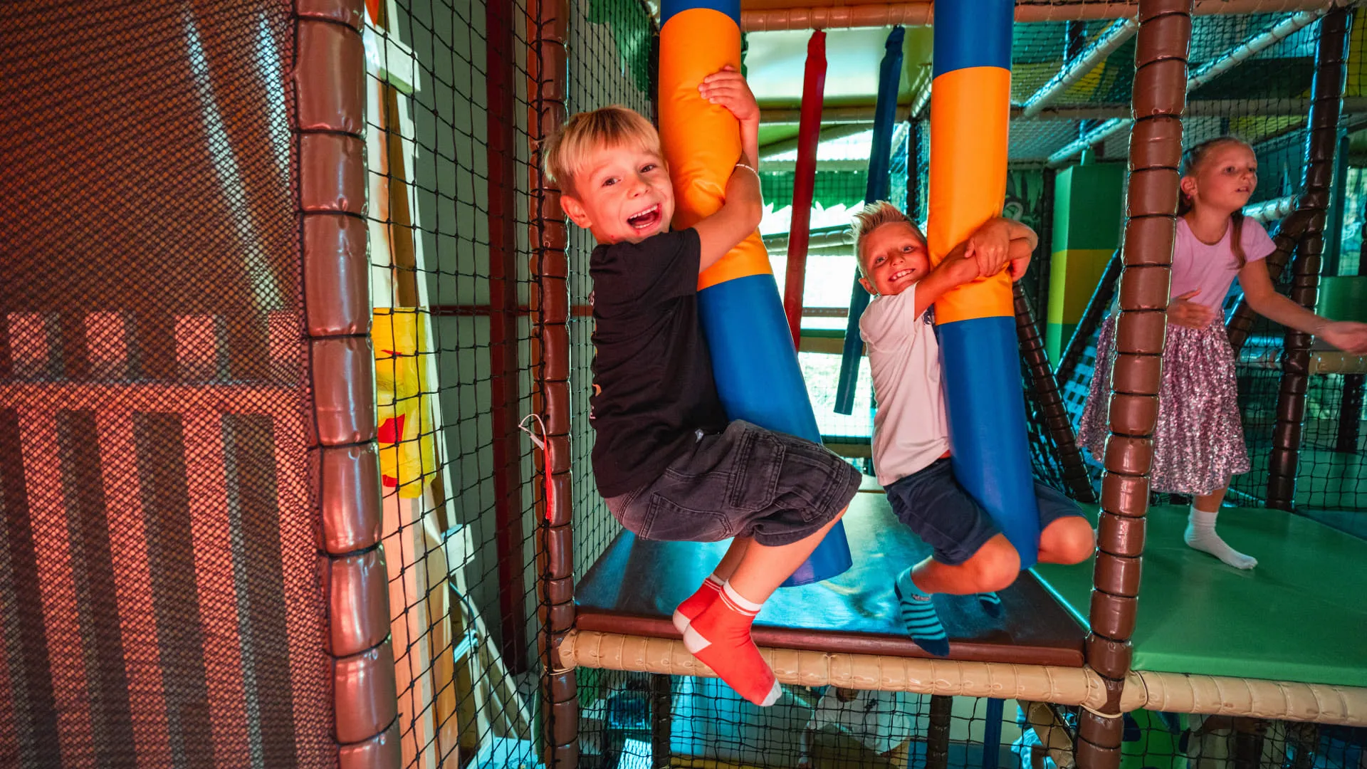 Kinder spielen in einem Indoor-Spielbereich.